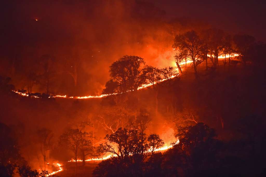 Spot fires burn on a hillside caused by a lightning strike in Brentwood, California