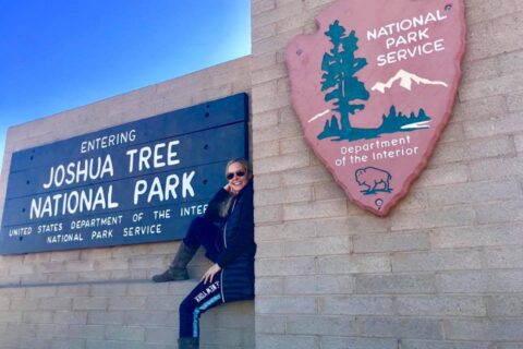 Sitting by the Joshua Tree National Park sign