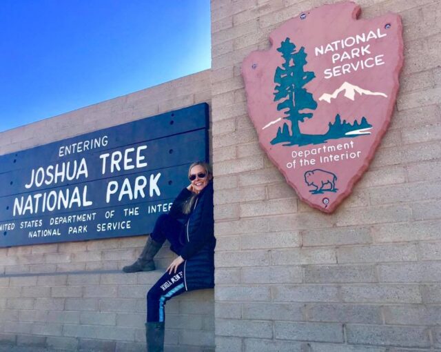 Sitting by the Joshua Tree National Park sign